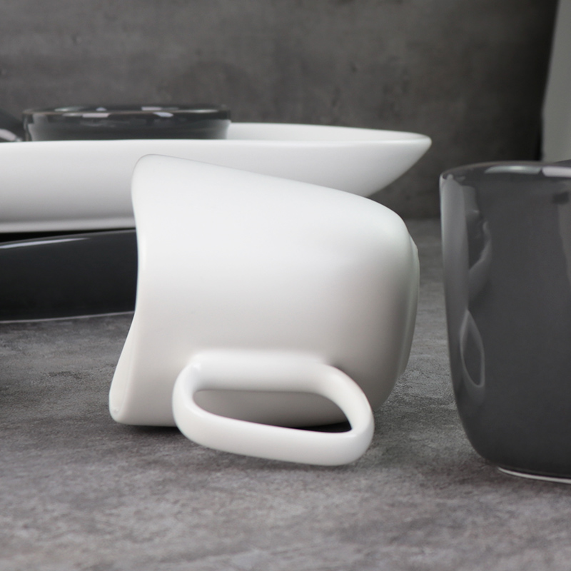 Căni din ceramică alb-negru sub căni din porțelan glazurat