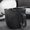 Căni din ceramică alb-negru sub căni din porțelan glazurat